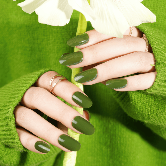 Hands with olive green gel nail wraps holding white flowers for nature-inspired nail art