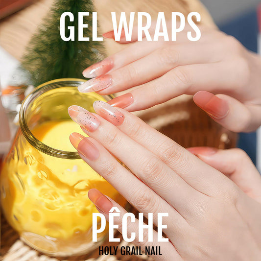 Peach ombre gel nail wraps on hands holding mug showing gradient sunset manicure