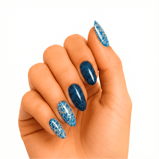 Blue snake print gel nail wraps on hand showing glossy navy and silver animal pattern