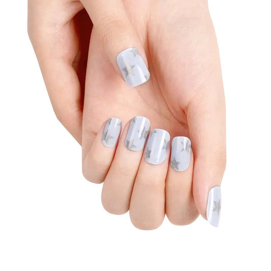 Blue sparkly gel nail wraps with silver stars on hand manicure