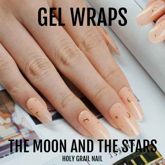 Peachy nude gel nail wraps with gold celestial moon and star designs on hand