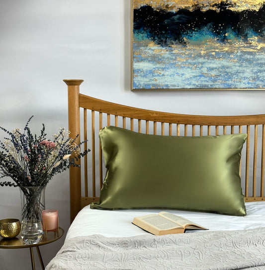 Avocado green silk pillowcase on wooden bed frame for luxurious hair and skin care