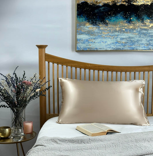 Champagne silk pillowcase on wooden bed frame in elegant bedroom setting
