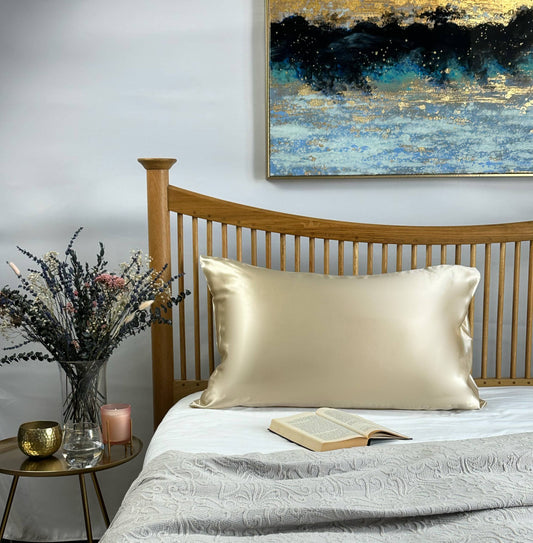 Prosecco champagne silk pillowcase on wooden bed with neutral bedroom styling for hair care
