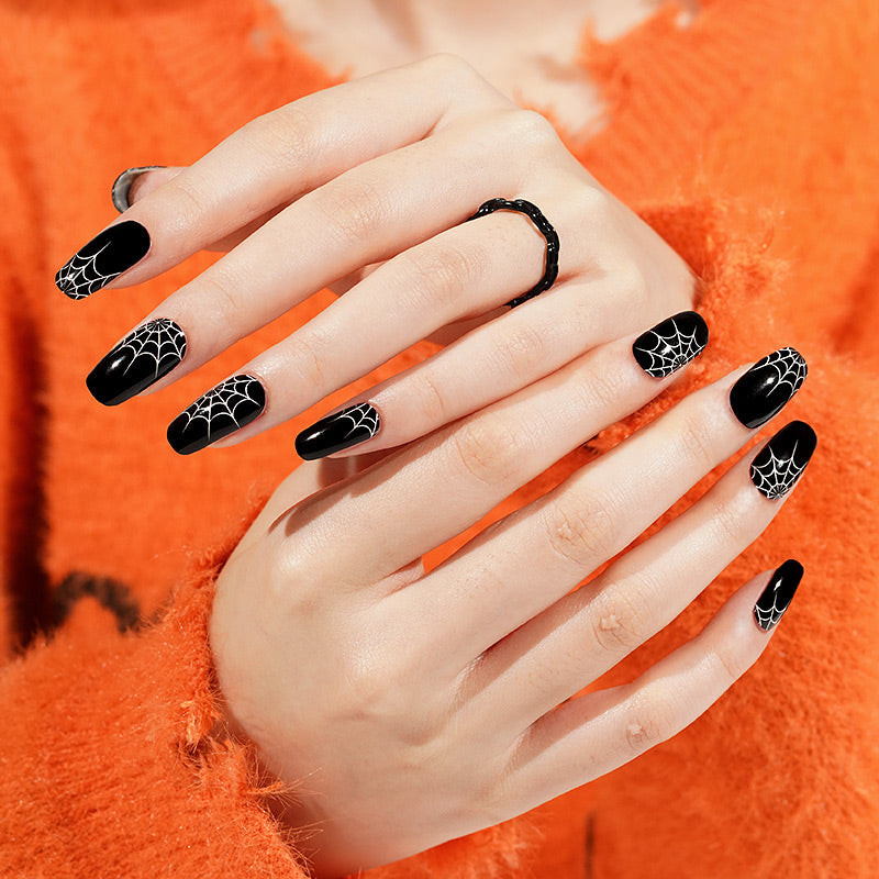 Black glossy semi-cured gel wraps with white spiderweb design on almond nails