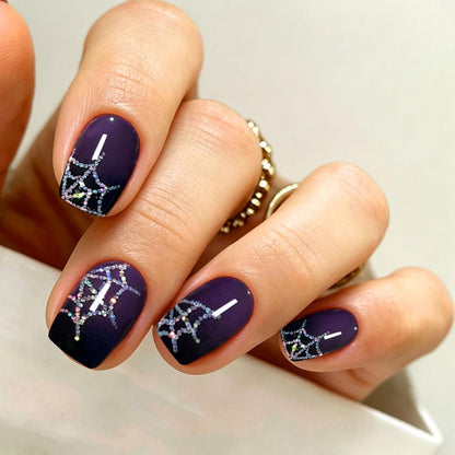 Deep purple semi-cured gel nail wraps with glittery silver spiderweb Halloween design.