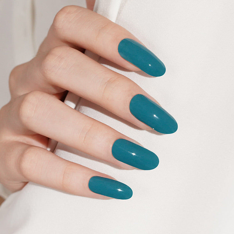 Semi-cured gel nail wraps in glossy teal green on almond-shaped nails