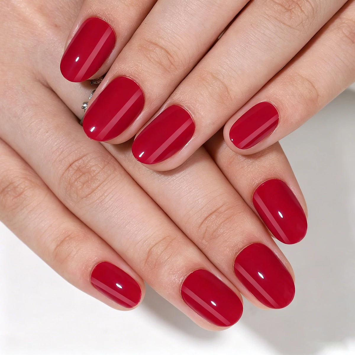 Glossy deep red short oval soft gel press-on nails with a high-shine finish