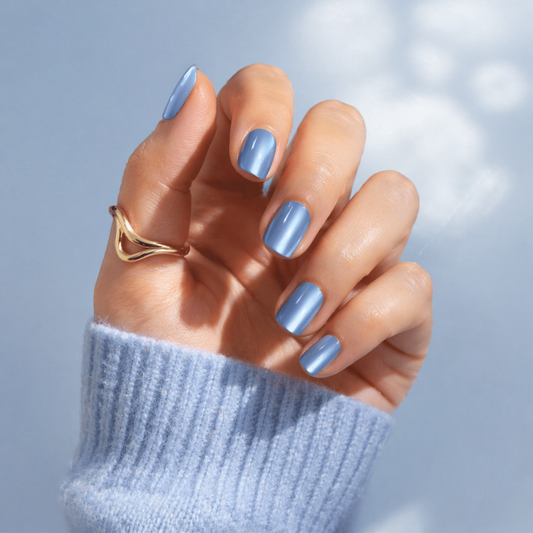 Powder blue cat's eye gel press-on nails with shimmer finish on hand with gold ring