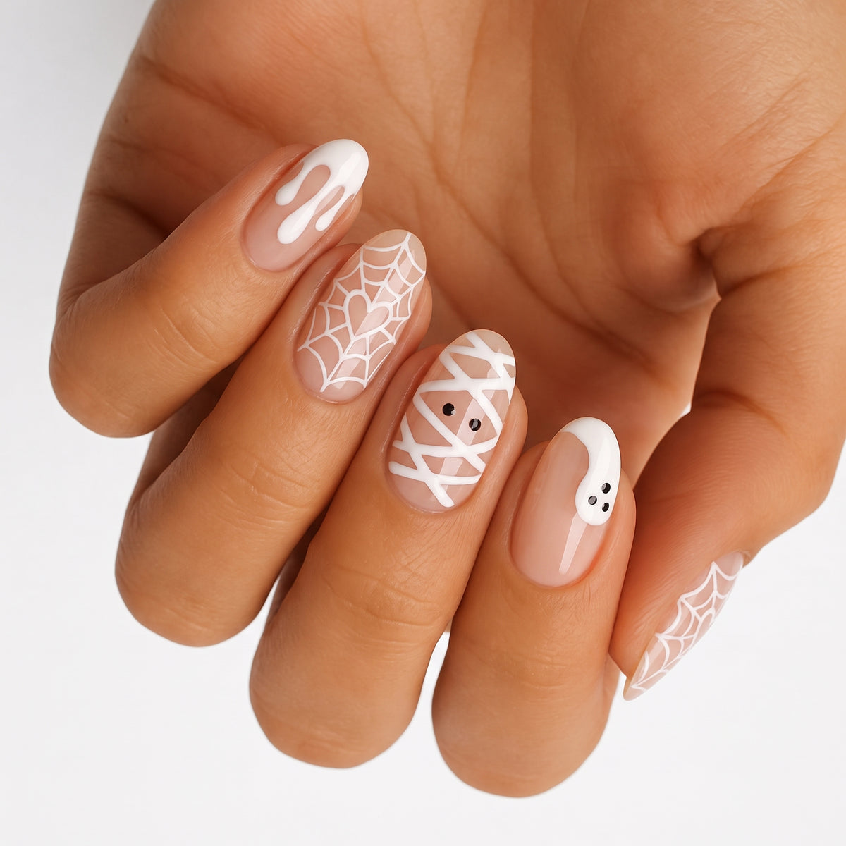 Nail wraps in sheer nude with white drip, spiderweb, mummy, and ghost Halloween designs