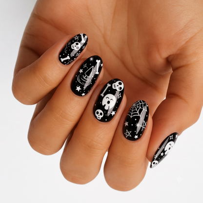 Black glossy nail wraps with white Halloween skulls, bones, spiderweb, and star designs