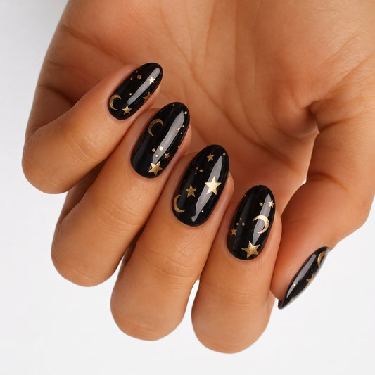 Glossy black nail wraps with gold moon and star celestial design, almond shape