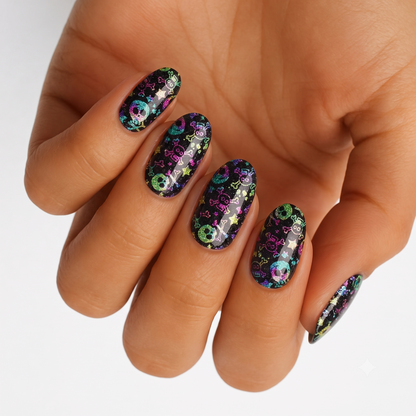 Black holographic press-on nails with colorful skull, crossbone, and star print design.