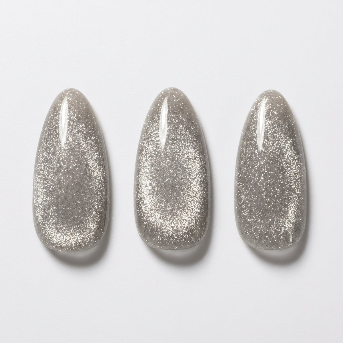 Grey soft gel press-on nails with shimmering cat's eye glitter effect, medium almond shape