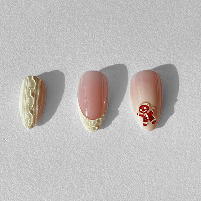 Nude pink soft gel press-on nails with cream icing swirl edging and gingerbread man design