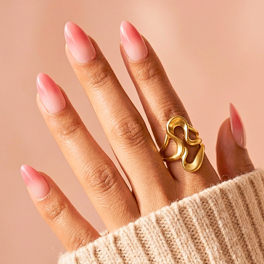Coral pink glossy press-on nails short almond shape on hand with gold rings