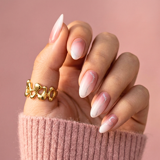 Pink ombre French tip press-on nails in short almond shape on hand with gold ring