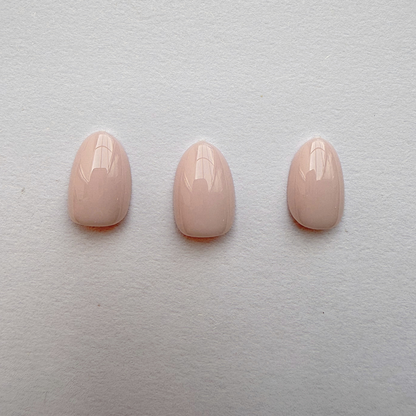 Solid nude pink glossy press-on nails, short round almond shape, set of three.