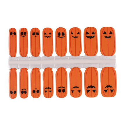 Orange nail wraps with jack-o'-lantern pumpkin faces, glossy Halloween nail design