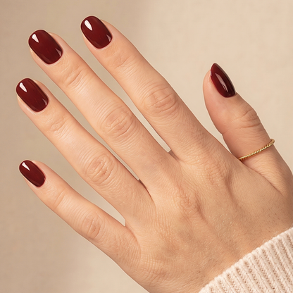 Deep oxblood red glossy soft gel press-on nails, extra short natural round shape.