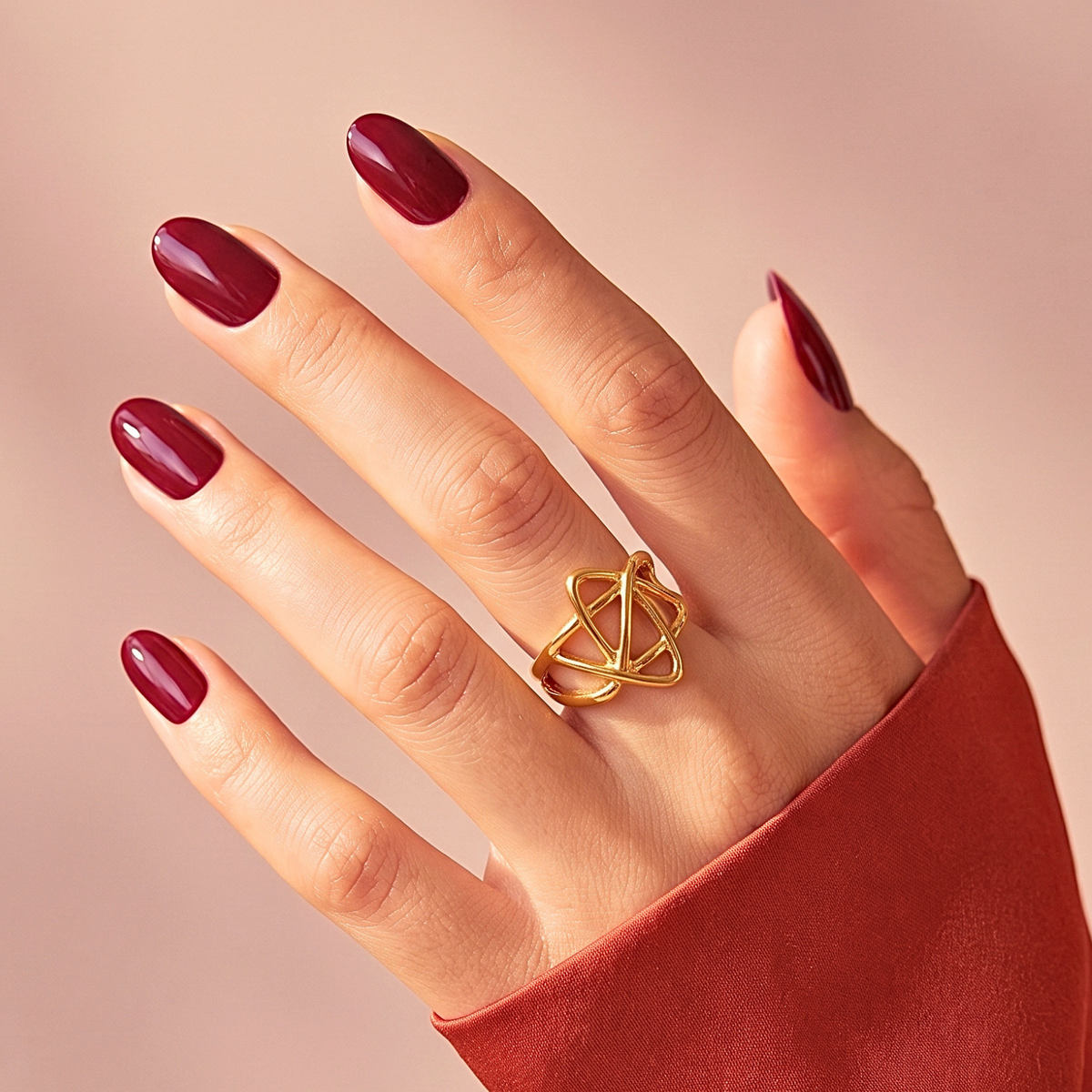 Deep burgundy glossy soft gel press-on nails in a short oval shape, solid colour.