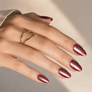 Deep red almond-shaped press-on nails with shimmering metallic cat-eye finish.