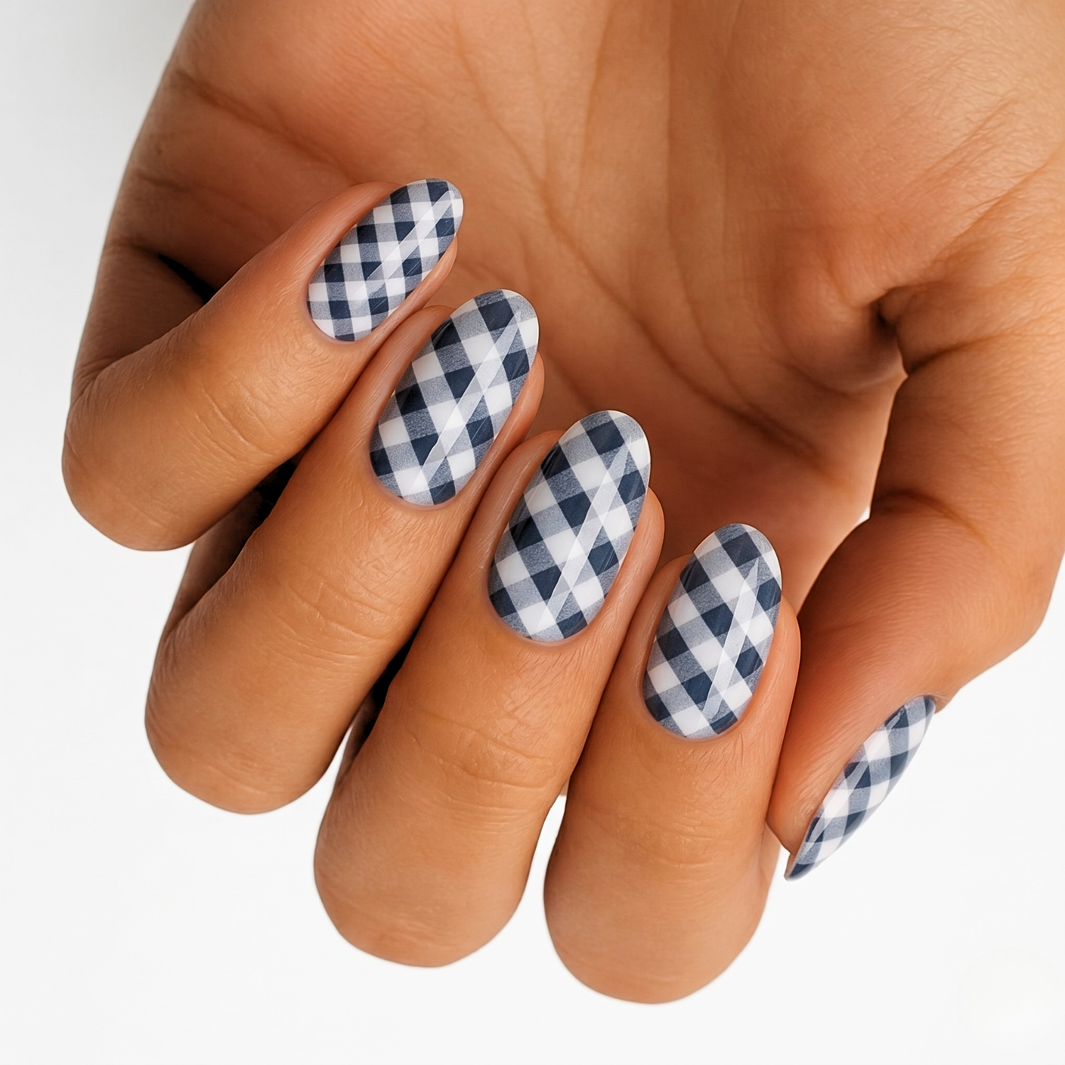 Black and white tartan nail wraps on hand displaying checkered plaid nail art