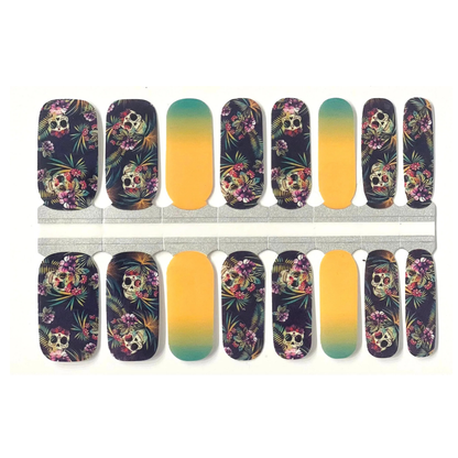 Nail wraps with floral sugar skull print, paired with teal-to-yellow ombre accent nails.