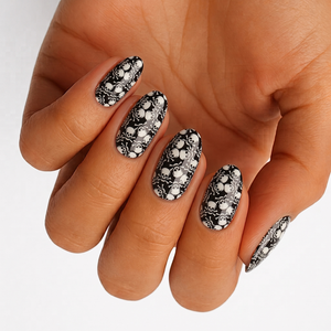 Black glossy nail wraps with white skull and crossbones print, almond shape