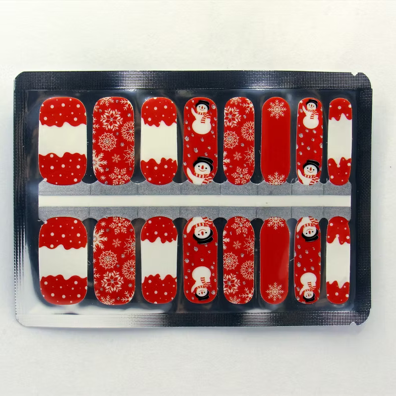 Red and white nail wraps with snowmen, snowflakes and glitter accents, festive design