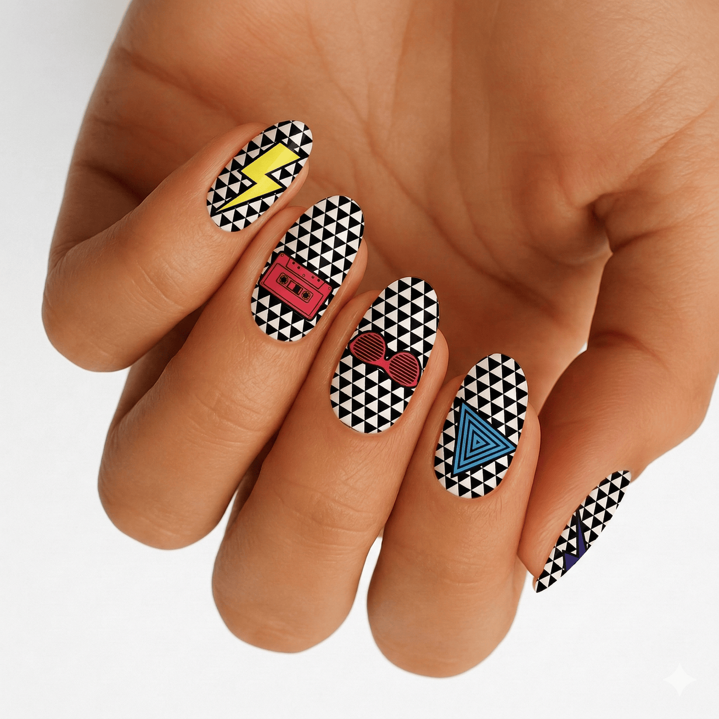 Hand displaying geometric black white nail wraps with colourful 80s retro triangle pattern design