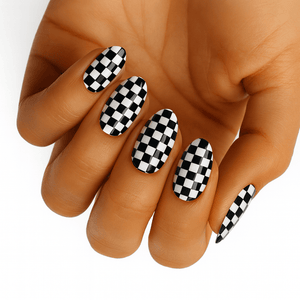 Black and white checkered gel nail wraps on hand showing chessboard pattern manicure