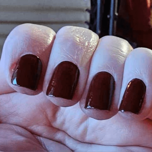 Deep brown glossy nail wraps on hand showing coffee bean finish for at-home manicure