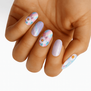 Pastel watercolour floral nail wraps on hand featuring purple blue and pink flower designs