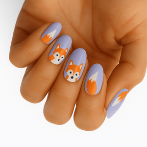 Cute fox nail wraps on hand featuring orange and grey cartoon foxes on lilac base