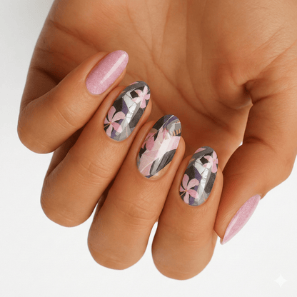 Pink and grey floral nail wraps on hand featuring botanical cherry blossom pattern for at-home manicure