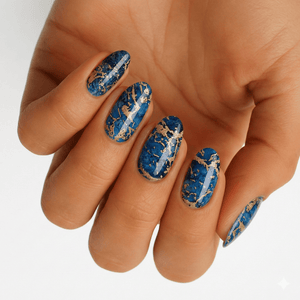Blue lapis lazuli nail wraps with gold veining on hand showing marble stone effect
