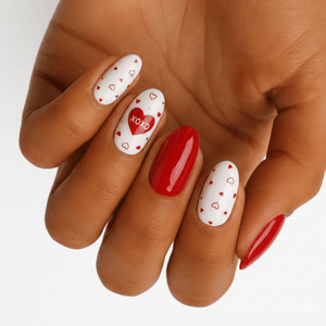 Red and white XOXO nail art on hand featuring glossy heart pattern nail wraps