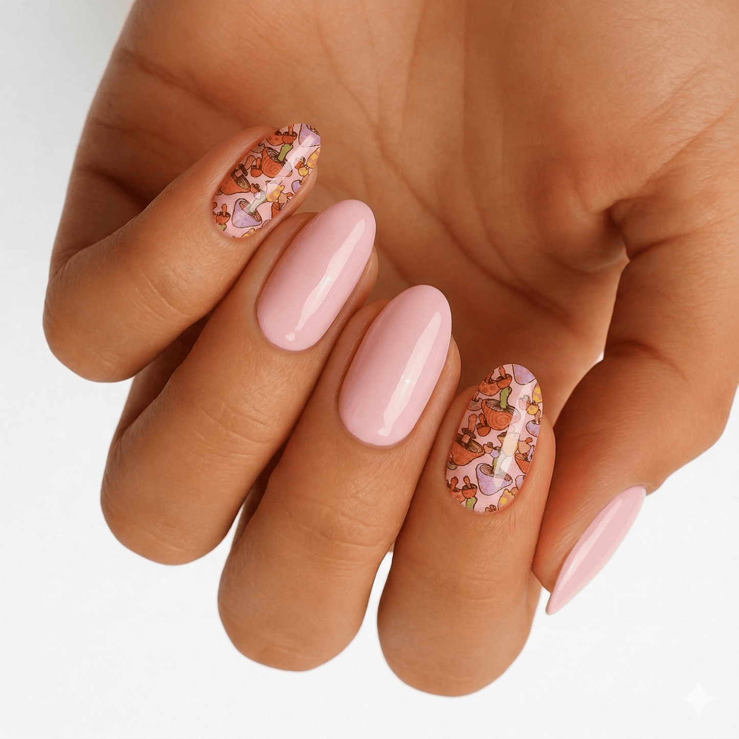 Pink fairytale mushroom nail art wraps on hand with botanical design