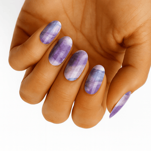 Purple marble pattern nail wraps on hand displaying watercolor veining design for at-home manicure