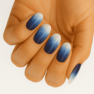Blue ombre gradient nail art on hand showing powder blue to navy nail wraps