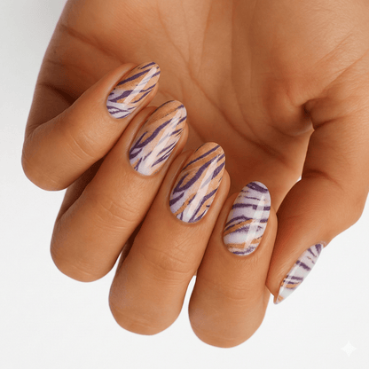 Purple metallic tiger stripe nail wraps on hand showing bold animal print nail art design