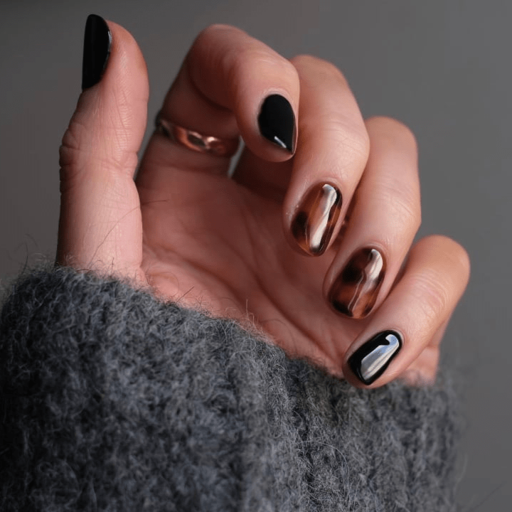 Hand displaying black and tortoiseshell nail wraps for at-home manicure