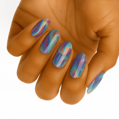 Holographic rainbow nail wraps on hand displaying chrome multicolour prismatic finish for festival looks