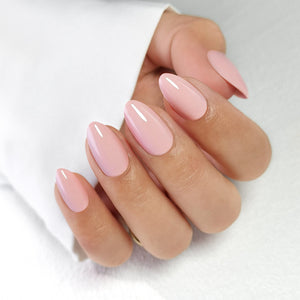 Pink glitter press-on nails in short almond shape on hand