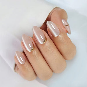 Rose gold cat's eye press-on nails on hand showing short almond gel nail extensions