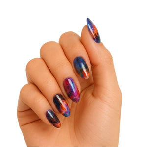 Cosmic galaxy gel nail wraps on hand showing iridescent purple blue chrome finish