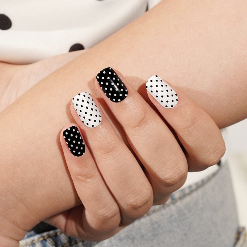 Monochrome dotted gel nail wraps showing black and white polka dot manicure design