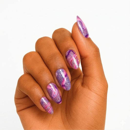 Purple and pink marble gel nail wraps with swirl pattern on woman's hand