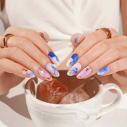 Blue marble watercolour gel nail wraps on hands holding ceramic mug